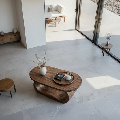 Walnut look coffee table with sculptural curved base and seamless top in a soft neutral home interior