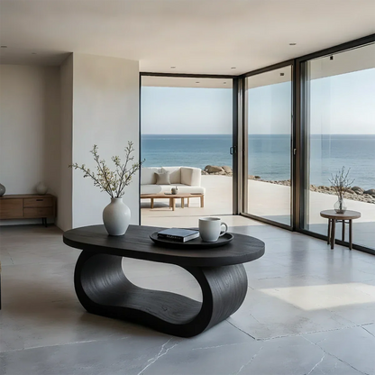 Black look coffee table with organic silhouette and smooth surface in a minimalist styled living room