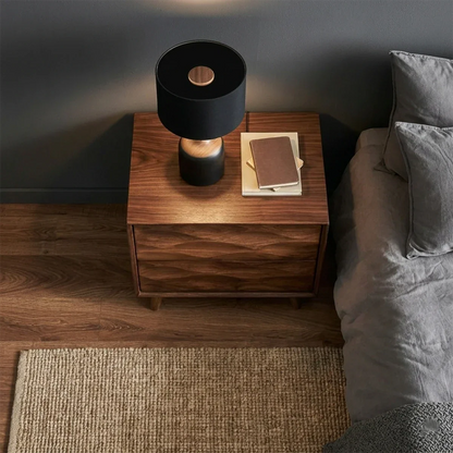 Compact bedroom side table designed with sculptural drawer detail and walnut tone finish