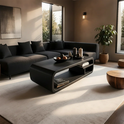 Coffee table in black color with artistic base design and smooth rounded edges in a bright modern space
